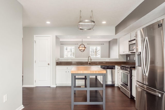 kitchen featuring dark wood-style floors, white cabinetry, stainless steel appliances, and a sink