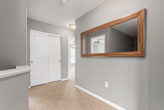 corridor featuring carpet floors and baseboards