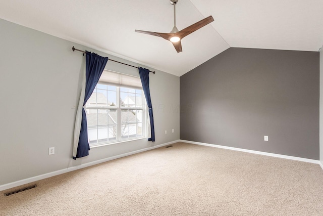 unfurnished room featuring ceiling fan, visible vents, baseboards, vaulted ceiling, and carpet