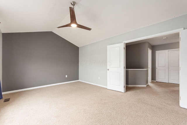 unfurnished bedroom with vaulted ceiling, carpet floors, visible vents, and baseboards