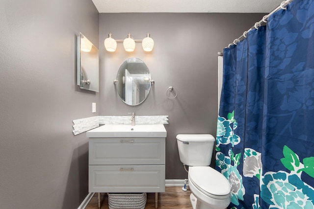 bathroom featuring a shower with shower curtain, toilet, vanity, wood finished floors, and baseboards