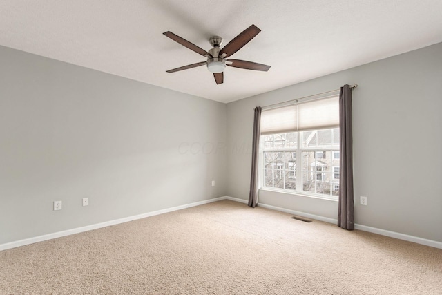 empty room with light carpet, visible vents, baseboards, and a ceiling fan