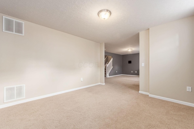 unfurnished room with stairway, baseboards, visible vents, and light colored carpet