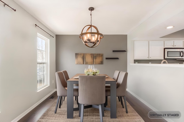 dining room with an inviting chandelier, visible vents, baseboards, and wood finished floors