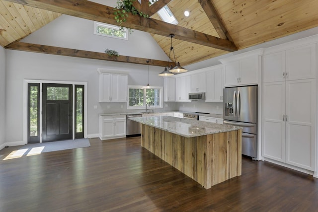 kitchen featuring light stone countertops, white cabinetry, a center island, stainless steel appliances, and dark hardwood / wood-style floors