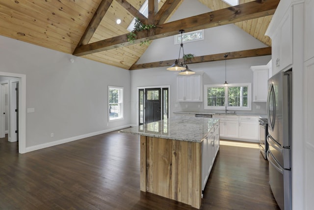 kitchen featuring a center island, stainless steel appliances, beamed ceiling, decorative light fixtures, and white cabinets