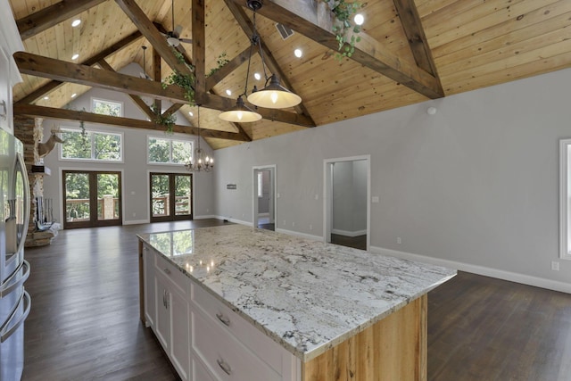 kitchen featuring dark hardwood / wood-style flooring, white cabinets, pendant lighting, beamed ceiling, and a center island