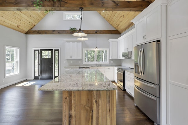 kitchen featuring appliances with stainless steel finishes, light stone counters, white cabinets, a center island, and hanging light fixtures