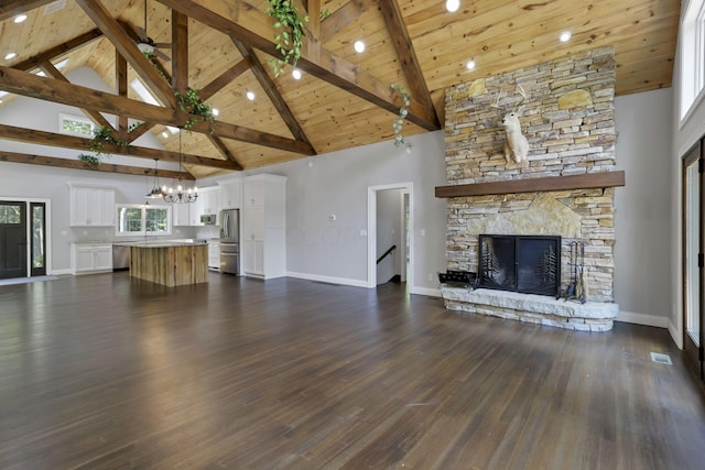 unfurnished living room featuring dark hardwood / wood-style floors, a stone fireplace, wooden ceiling, and high vaulted ceiling