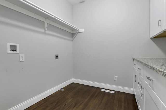 laundry room featuring electric dryer hookup, hookup for a washing machine, hardwood / wood-style floors, and cabinets