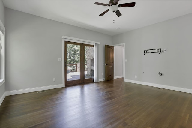 empty room with french doors, ceiling fan, and dark wood-type flooring