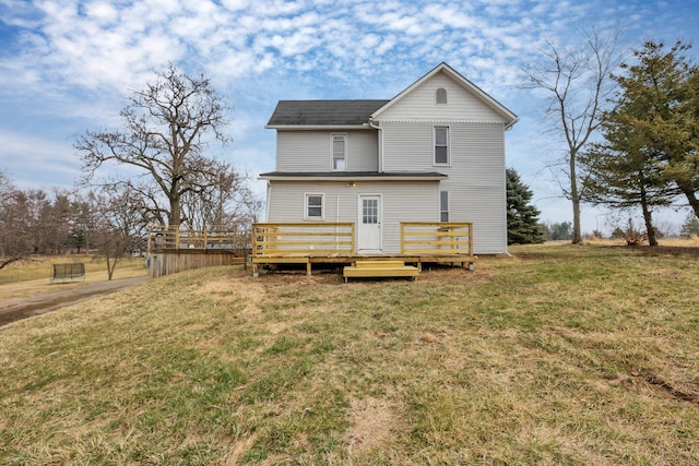 rear view of house featuring a lawn and a wooden deck