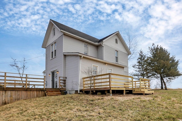 rear view of property featuring a lawn and a wooden deck