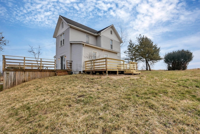 back of property featuring a lawn and a wooden deck