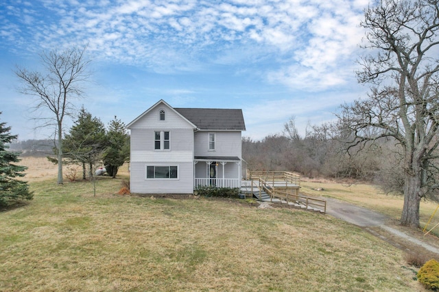 rear view of property featuring covered porch and a yard