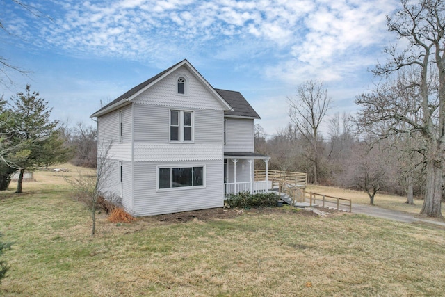 view of side of property featuring a lawn and a porch