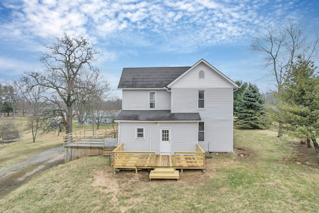 back of house featuring a lawn and a wooden deck