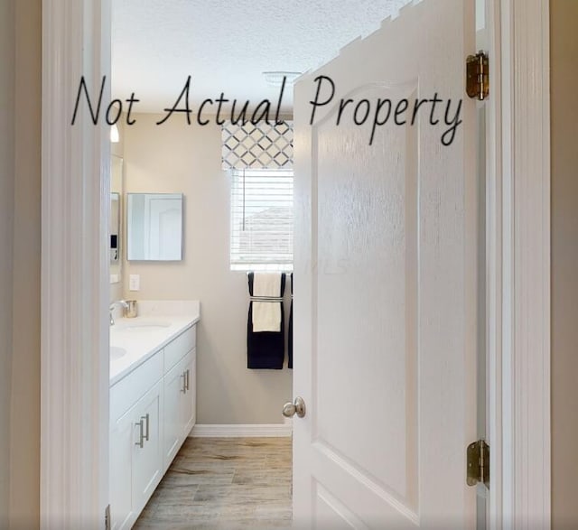 bathroom featuring vanity, a textured ceiling, and hardwood / wood-style flooring