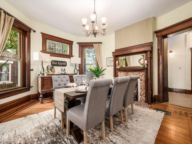 dining space with wood-type flooring and an inviting chandelier