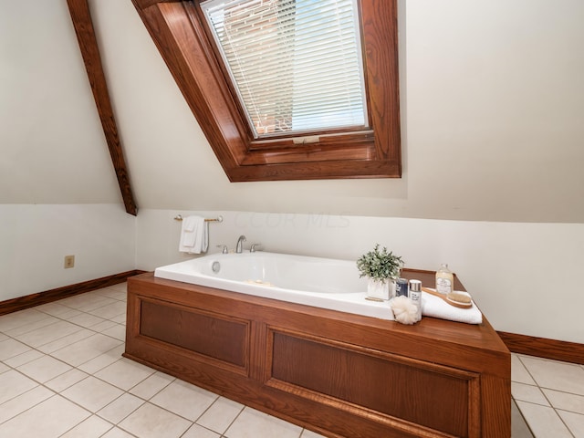 bathroom with tile patterned flooring, a bath, and vaulted ceiling