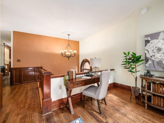 dining room with dark wood-type flooring and a notable chandelier