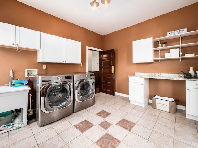 clothes washing area with separate washer and dryer, light tile patterned floors, and cabinets