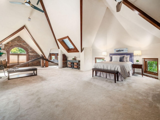 bedroom featuring carpet flooring, ceiling fan, high vaulted ceiling, and a skylight