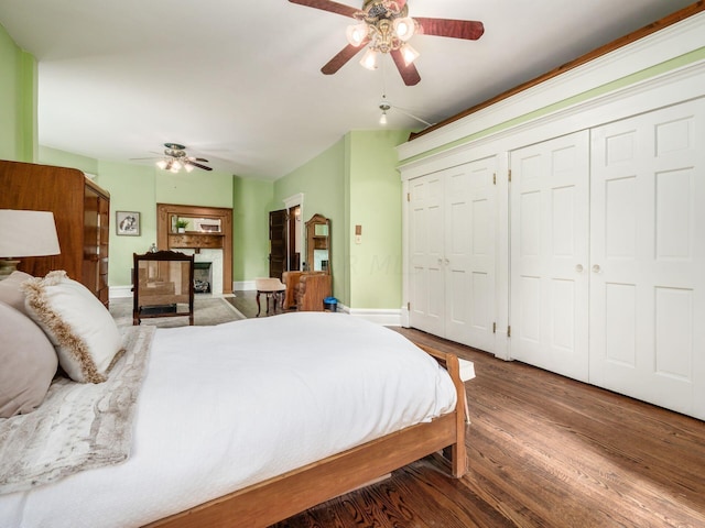 bedroom featuring hardwood / wood-style flooring, ceiling fan, and two closets