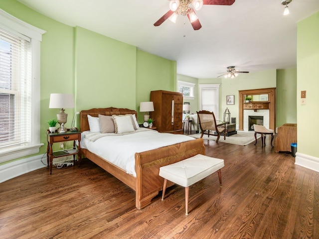 bedroom with dark hardwood / wood-style floors and ceiling fan