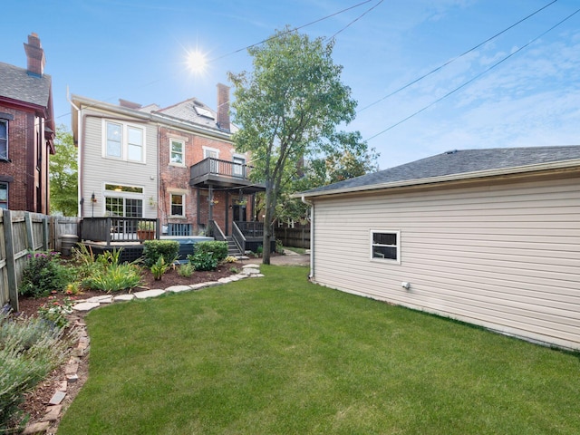 back of house with a lawn, a balcony, and a deck