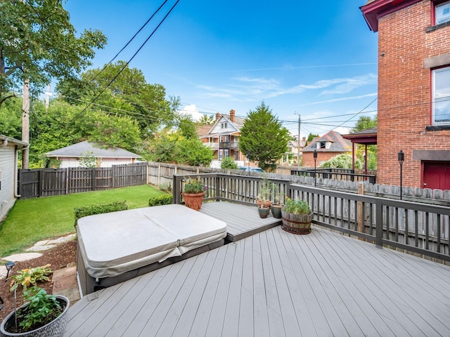 wooden deck with a yard and a covered hot tub