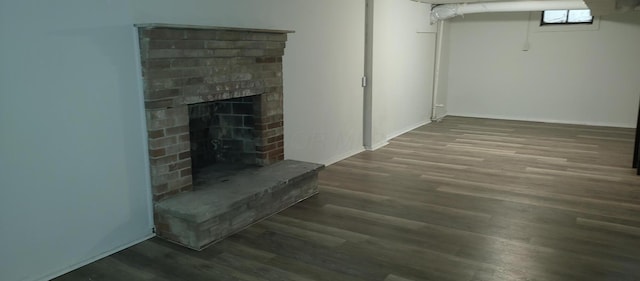 basement featuring a brick fireplace and hardwood / wood-style flooring