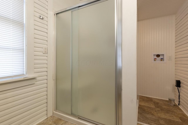 bathroom with walk in shower and wooden walls