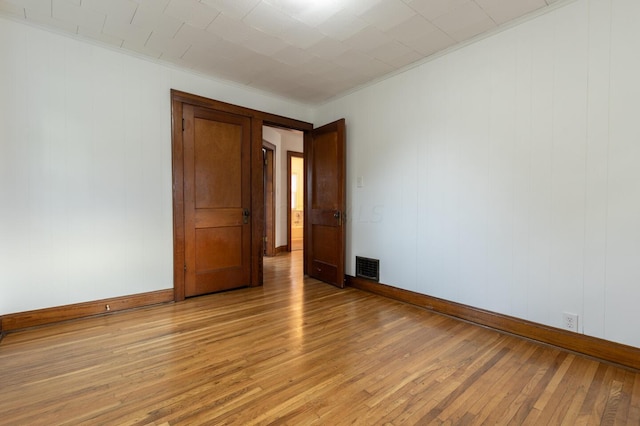 spare room featuring light hardwood / wood-style floors and crown molding