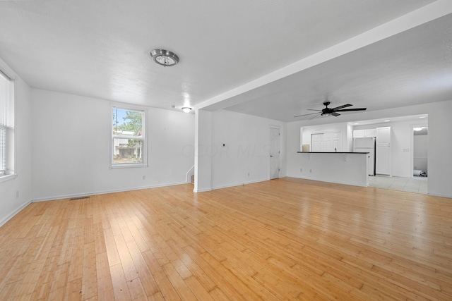 unfurnished living room featuring ceiling fan and light hardwood / wood-style flooring