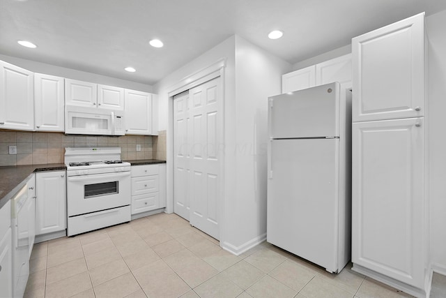 kitchen with light tile patterned floors, white appliances, white cabinetry, and backsplash