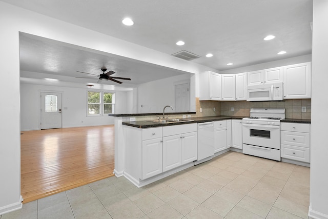 kitchen with white appliances, sink, light hardwood / wood-style flooring, white cabinetry, and kitchen peninsula