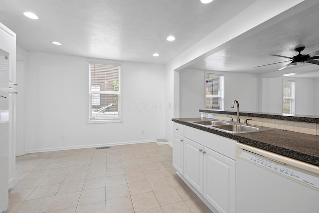 kitchen with ceiling fan, dishwasher, sink, light tile patterned floors, and white cabinets