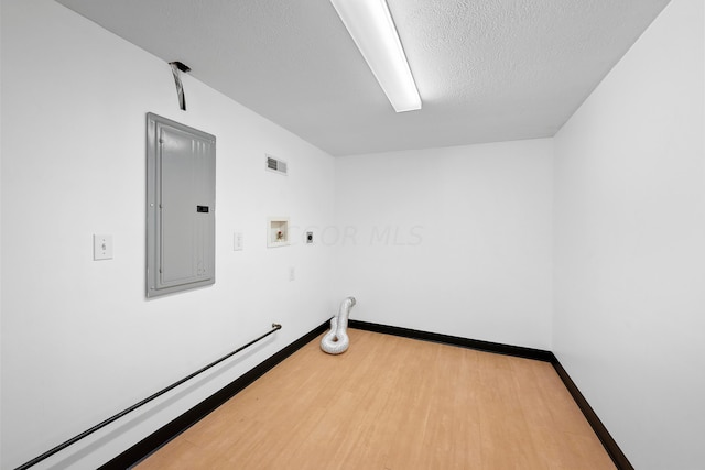 laundry area with electric panel, gas dryer hookup, hardwood / wood-style floors, hookup for a washing machine, and a textured ceiling