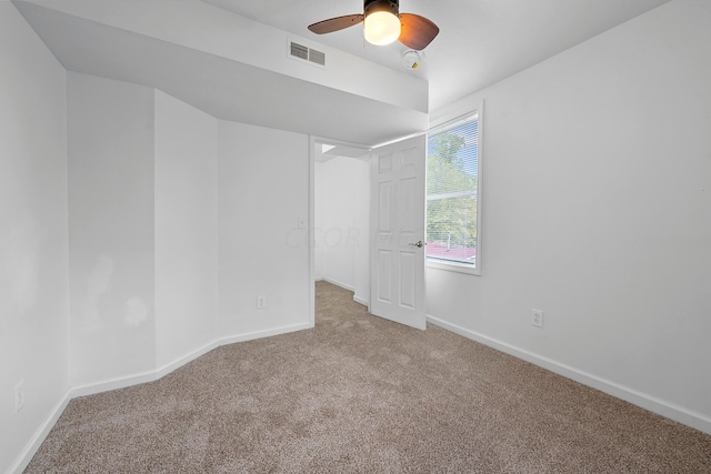 carpeted spare room featuring ceiling fan