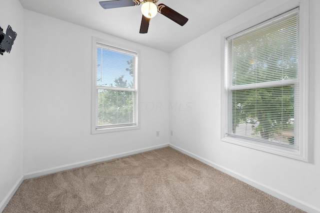 carpeted spare room with ceiling fan