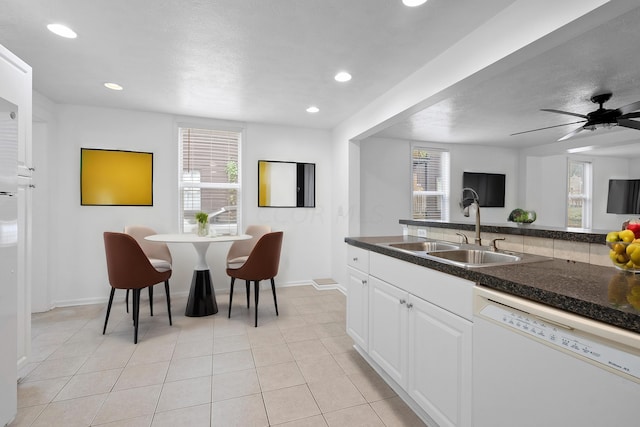 kitchen featuring ceiling fan, sink, dishwasher, white cabinetry, and light tile patterned flooring