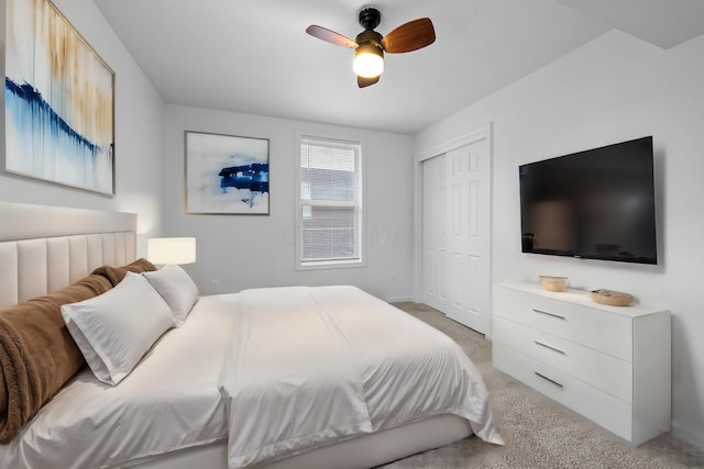 carpeted bedroom featuring ceiling fan and a closet