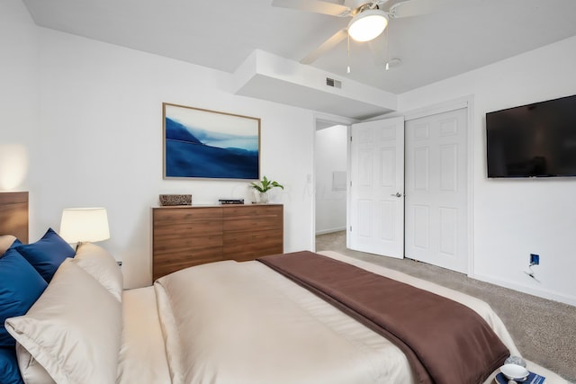 carpeted bedroom with ceiling fan and a closet