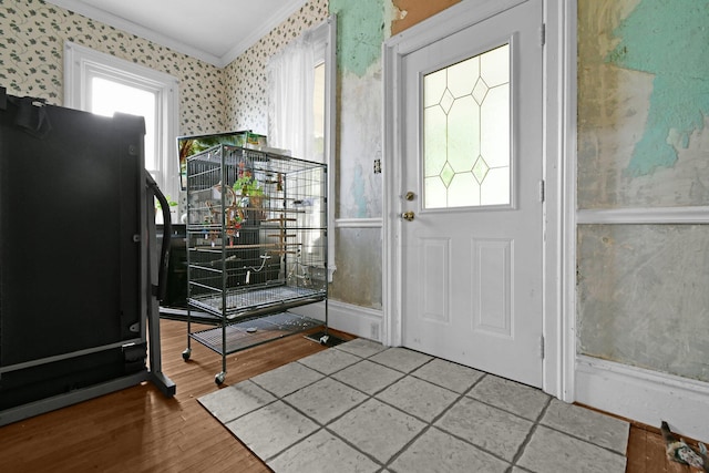 foyer entrance featuring hardwood / wood-style floors, a healthy amount of sunlight, and ornamental molding