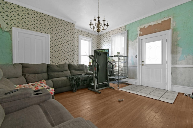 interior space with wood-type flooring, ornamental molding, and an inviting chandelier