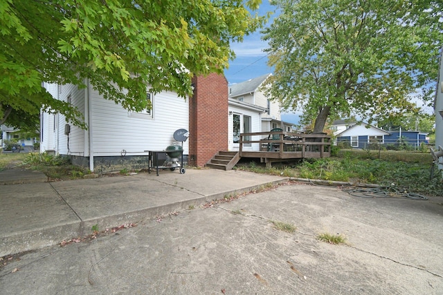 view of side of property featuring a patio and a deck