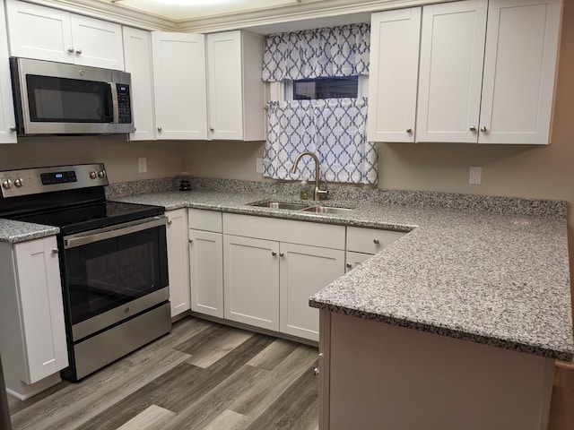 kitchen with appliances with stainless steel finishes, light stone countertops, and white cabinets