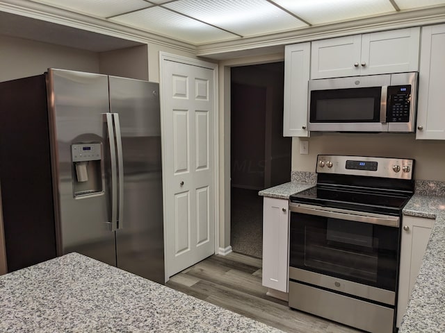 kitchen with appliances with stainless steel finishes, light stone countertops, and white cabinets