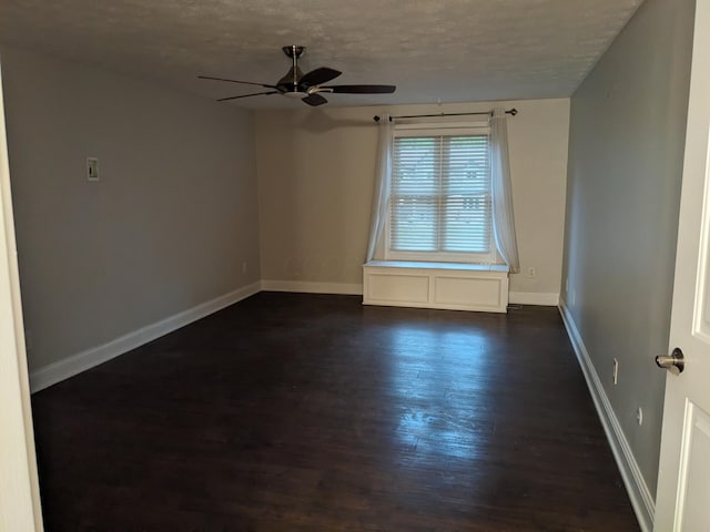 spare room featuring ceiling fan, dark hardwood / wood-style floors, and a textured ceiling